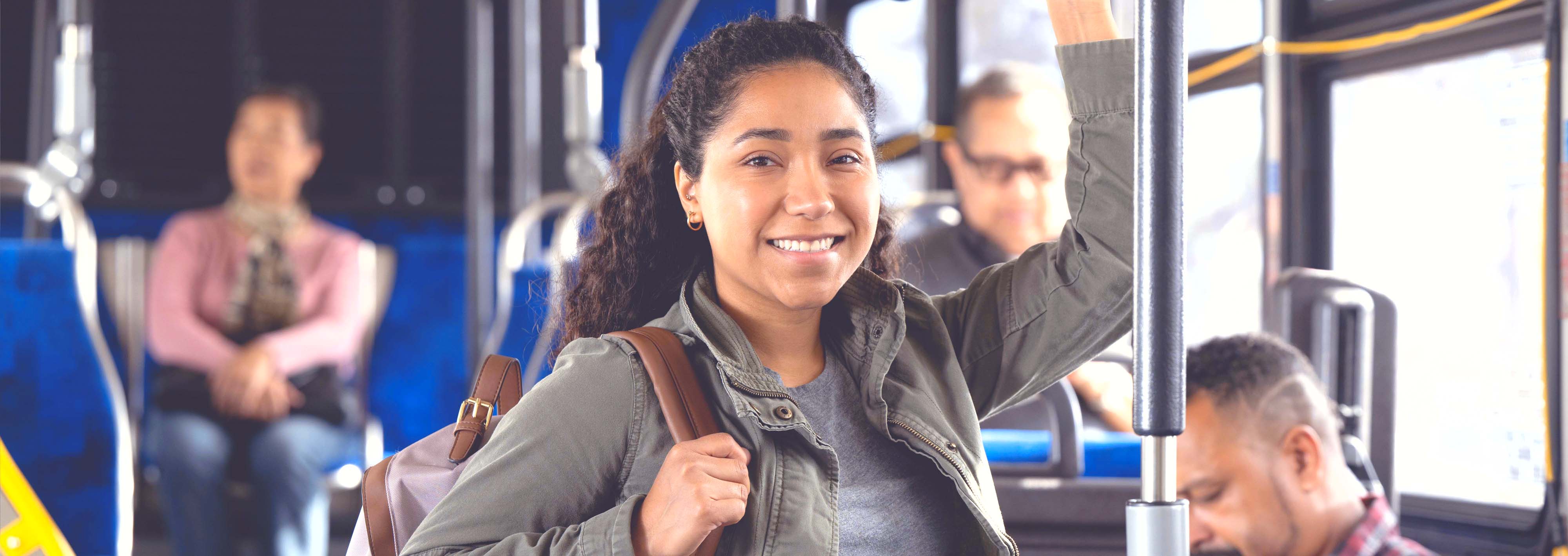 A young female rider smiles on the bus