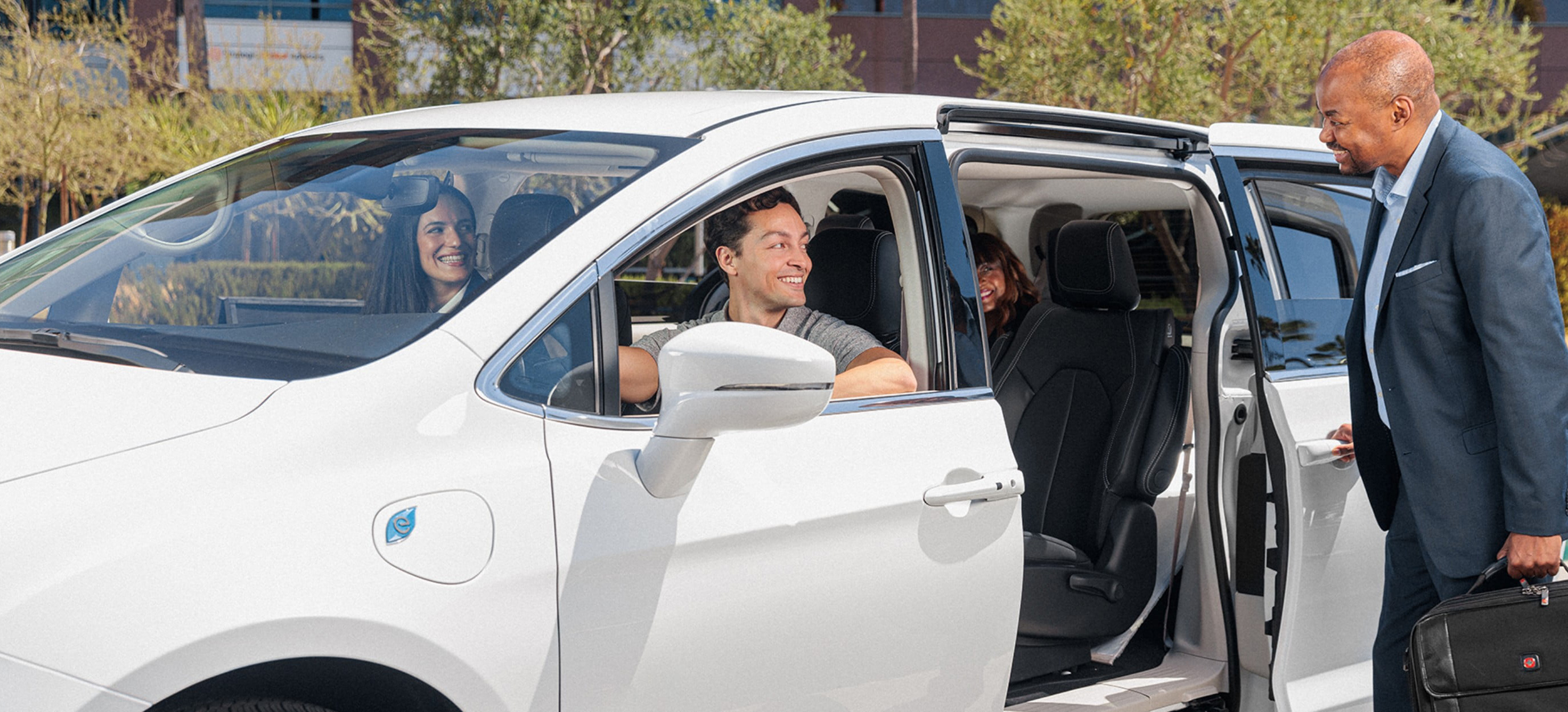 A group of business associates ride in a white van